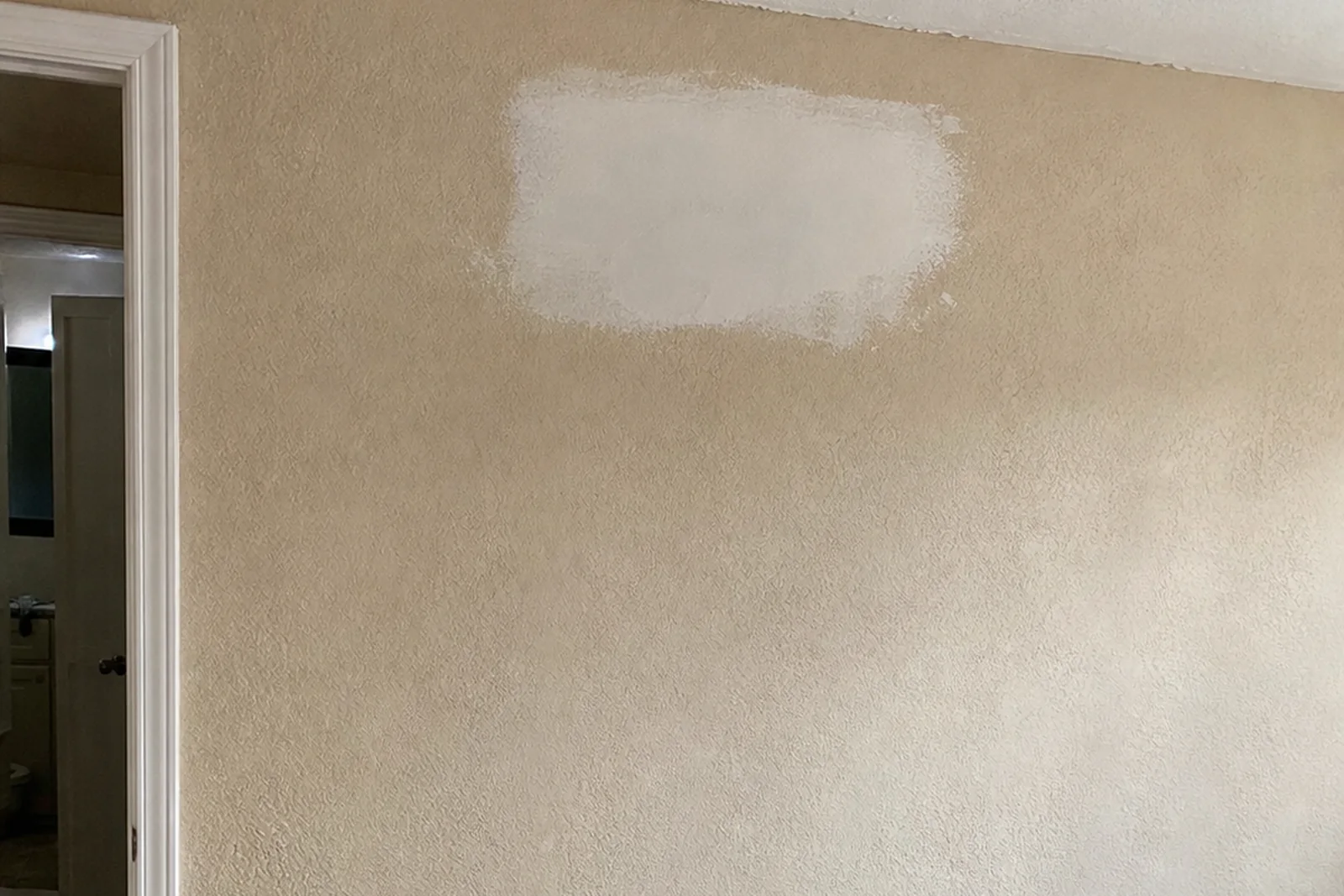 Texture matching drywall repair on an Idaho Falls Idaho home wall with drop cloth and compound pan